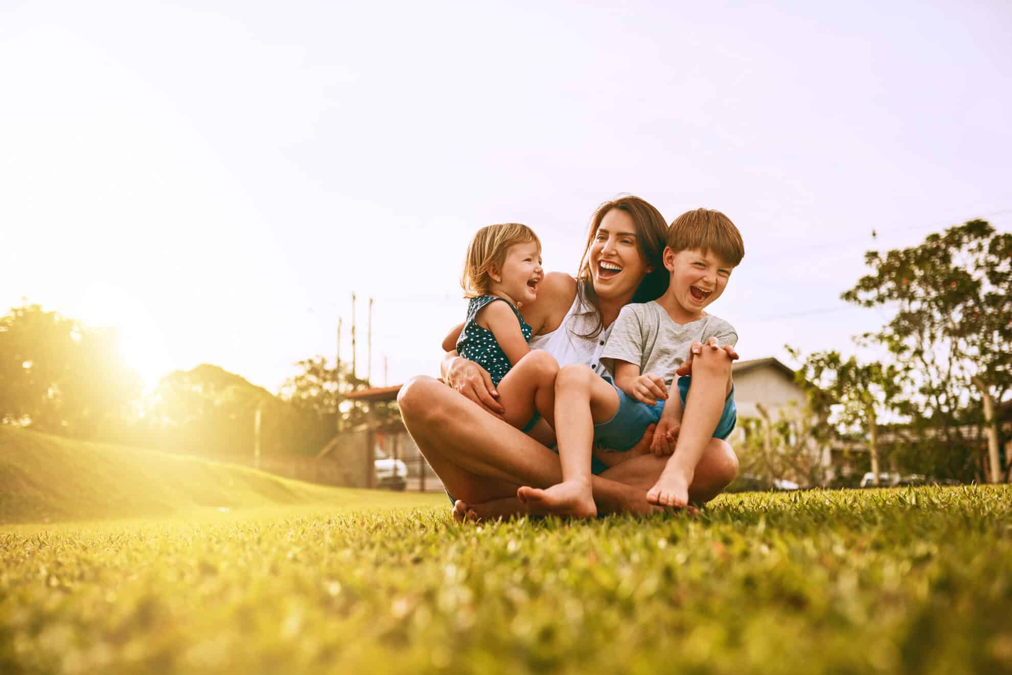 young mother and children outside at sunset