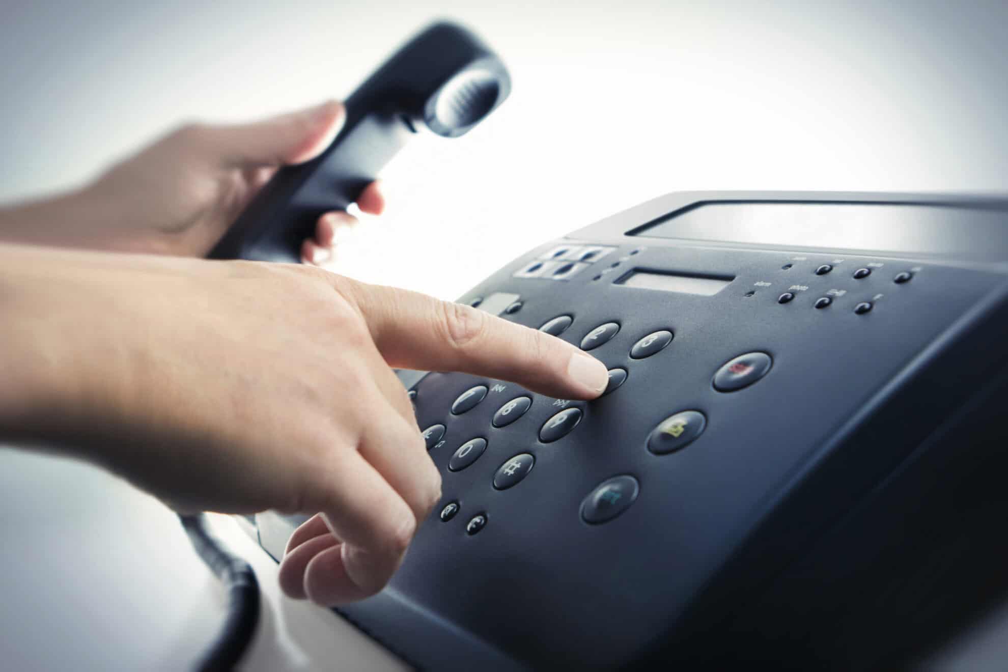 person's hand dialing phone