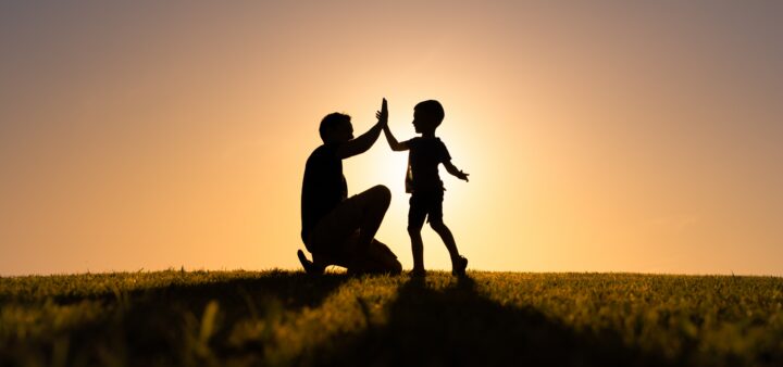 Father giving son high five.